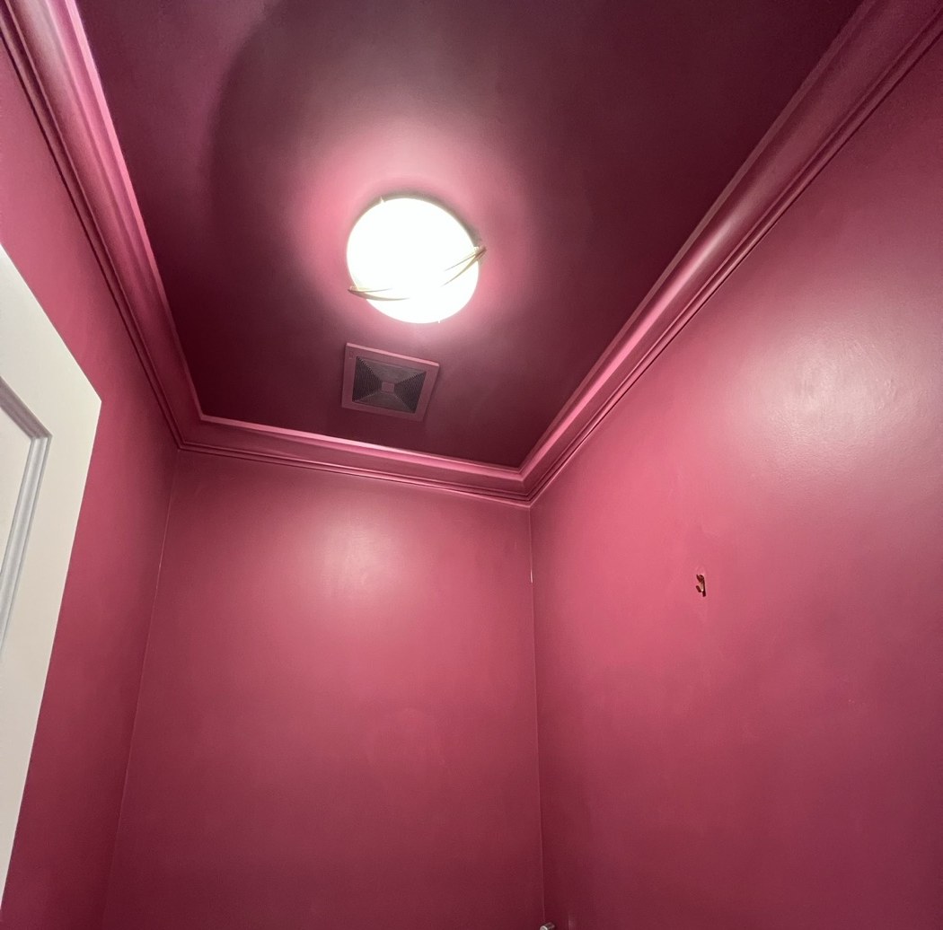Powder room painted deep raspberry — walls, ceiling and crown molding